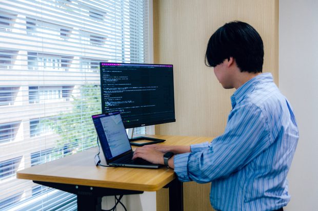 スタンディングデスクで開発する社員