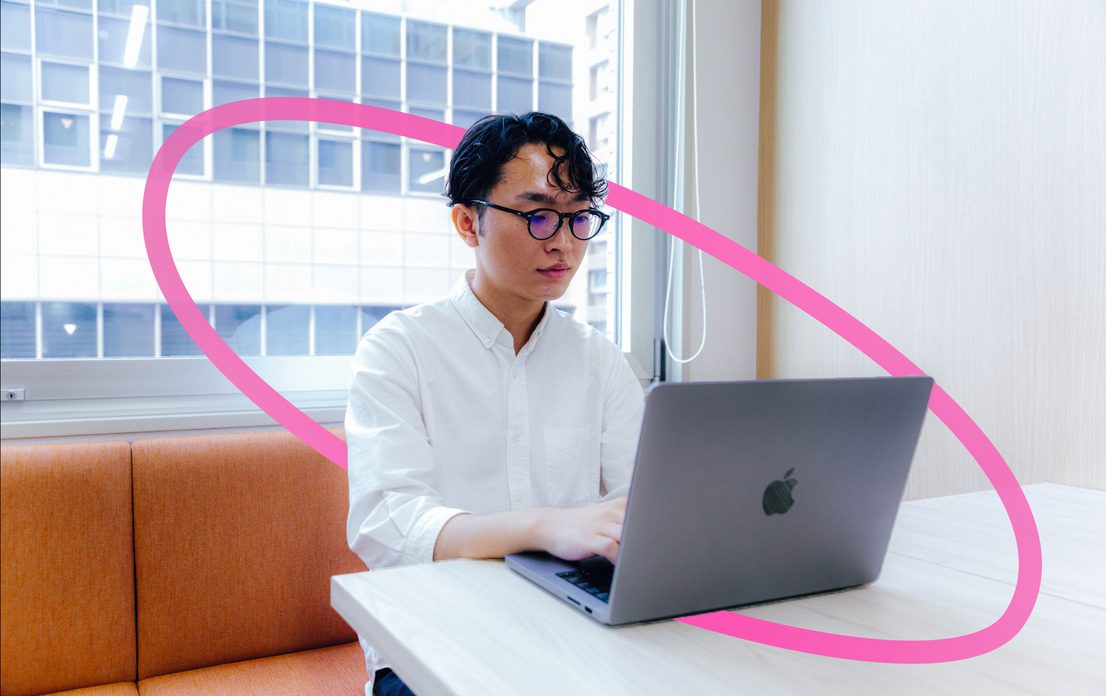 窓際の席でノートPCに向かう社員